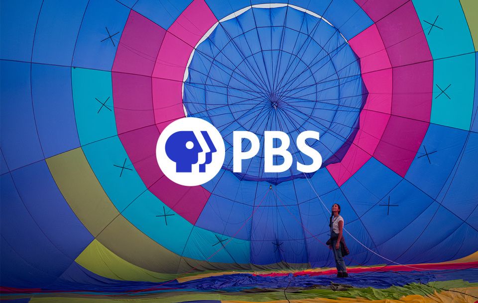 PBS logo and a girl standing on the ground in front of a large colorful parachute 